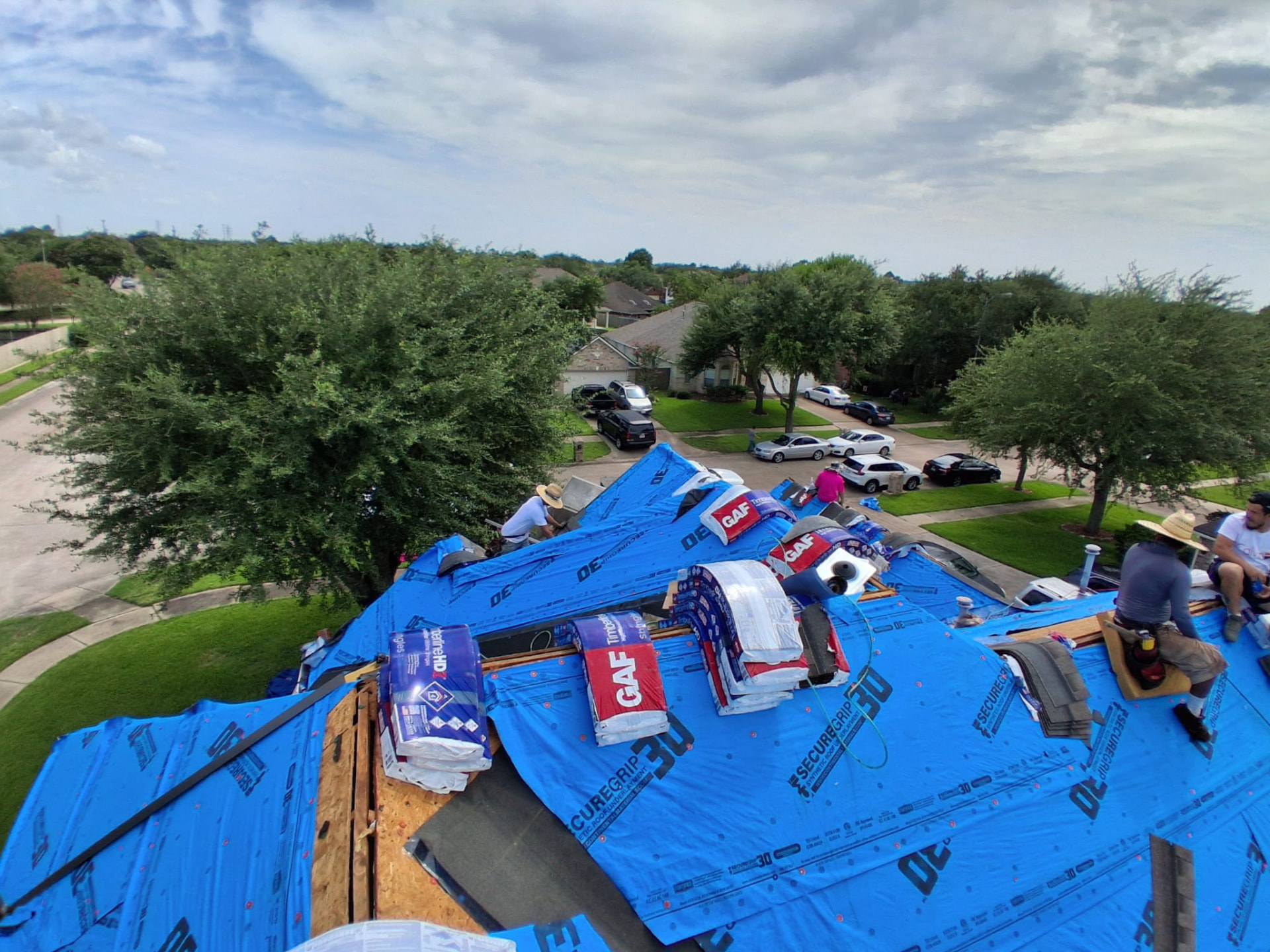 Equipo de Taboras Roofing instalando protección sobre un techo residencial en Houston